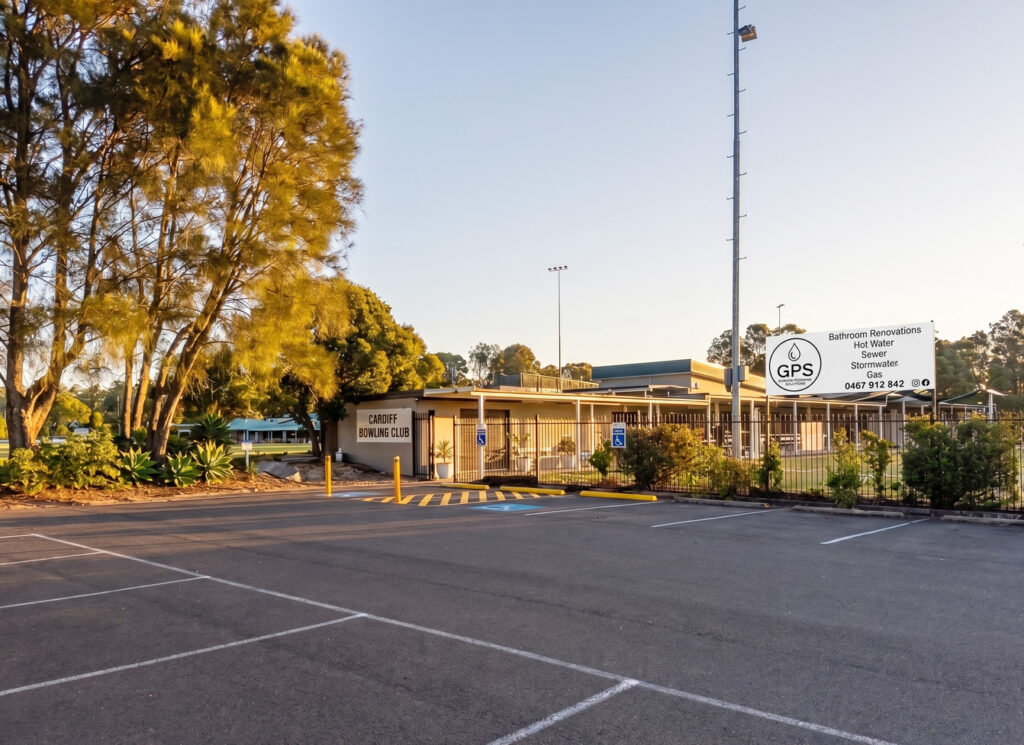 An exterior shot of the Cardiff Bowling Club parking lot at sunset